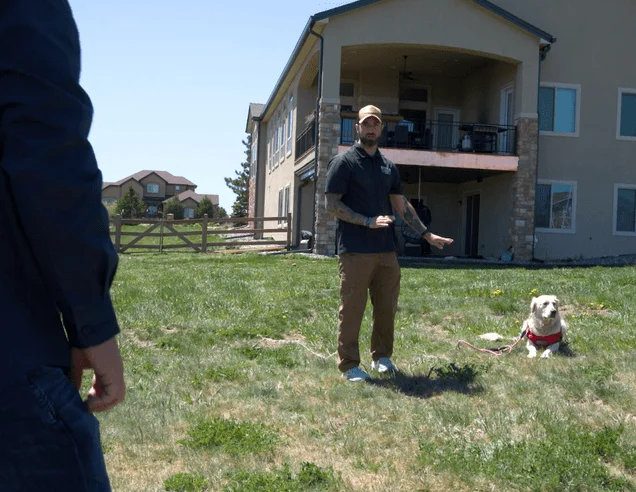 Person with service dog, person is signaling to service dog